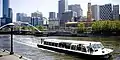 A flat boat is seen cruising along the Yarra River in Melbourne, Australia