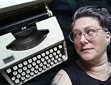 A Brother Charger typewriter on the left, Butler Hallett looking at the typewriter on the right.