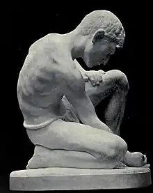 A marble sculpture of a boy playing marbles