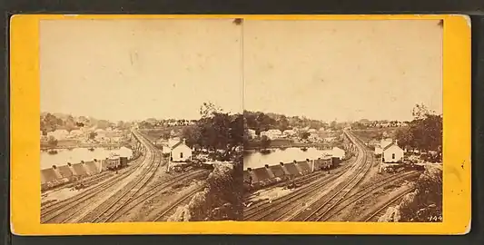 Falls of Schuylkill, from the western side of the river. The Reading Railroad Bridge (built 1853–56, still in use) is at the approximate location of the Chain Bridge. One of the buildings on the far shore may be White & Hazard's rolling mill. Laurel Hill Cemetery is visible at upper right.
