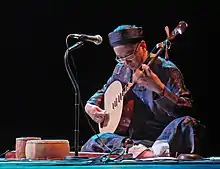Man is playing the đàn nguyệt.