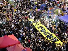 Hong Kong protesters holding a banner reading "I want real universal suffrage."