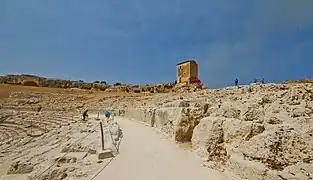 The final steps of the Greek theatre, the Casetta dei mugnai and the cavity of the Grotta del Ninfeo in the distance