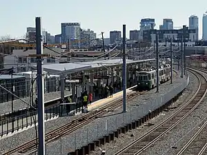 A light rail station next to a railway line in an urban area