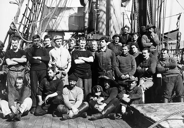 A crew sat on the deck of a ship