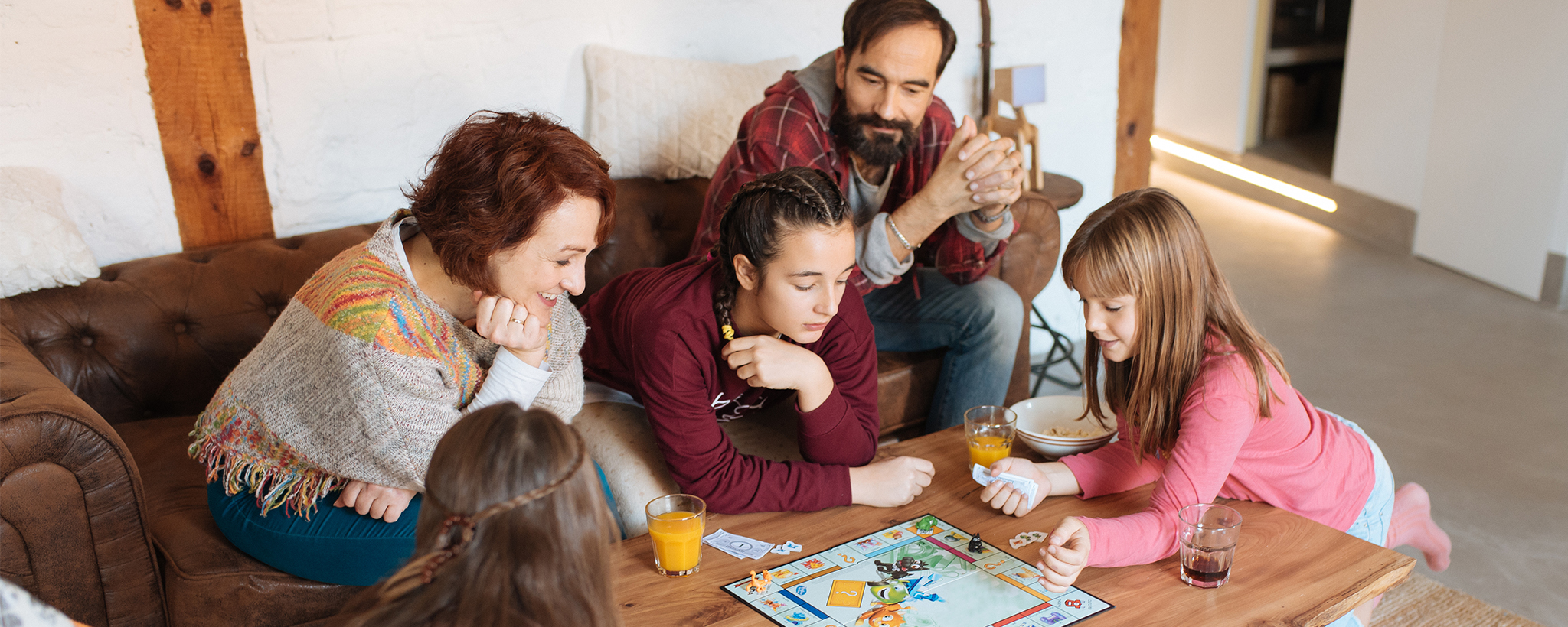 Una familia sentada alrededor de una mesa jugando un juego de mesa