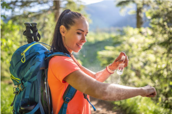 woman applying mosquito repellent